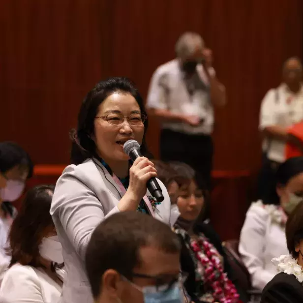 Woman asking a question at an event