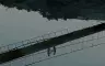 Screencap of a clip from an indigenous Taiwanese film, picturing the reflection of two people on a bridge in a body of water